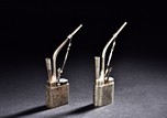 A GROUP OF TWO METAL OPIUM PIPES