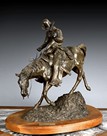 A CAST BRONZE COWBOY STATUE WITH THE TITLE 'THE RIDE FOR LIFE'