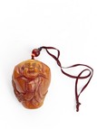 AN AMBER 'LUOHAN' PENDANT