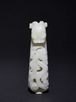 A WHITE JADE OR GLASS CARVED BELT HOOK