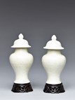 A PAIR OF WHITE GLAZED VASES AND COVER