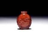 AN AMBER CARVED 'CHILONG' SNUFF BOTTLE