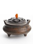 A BRONZE TWO-HANDLED TRIPOD CENSER WITH COVER 