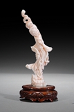 AN ANGEL-SKIN CORAL CARVING OF BEAUTY WITH THE ORIGINAL WOOD BASE