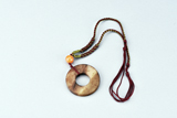 AN ARCHAIC JADE DISC WITH AMBER BEAD