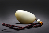 A NATURALISTIC WHITE JADE PEBBLE PENDANT