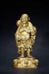 A GILT-BRONZE FIGURE OF STANDING BUDAI