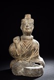 A SEATED POTTERY FIGURE
