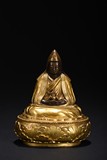 A GILT-BRONZE FIGURE OF GURU