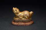 A GILT BRONZE MODEL OF MYTHICAL BEAST WITH STAND