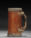 A BAMBOO MUG WITH BRONZE ENCLOSURES