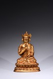 A GILT-BRONZE FIGURE OF GURU
