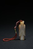 A CARVED WHITE AND RUSSET JADE FIGURE PENDANT