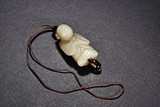 A CELADON JADE FIGURE PENDANT
