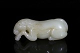 A WHITE JADE CARVED RECUMBENT HORSE