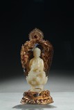 A WHITE JADE BUDDHA WITH GILT FILIGREE STAND
