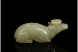 A CELADON JADE CARVING OF RECUMBENT DEER