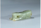 A CELADON JADE CARVING OF RECUMBENT TIGER