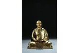 A GILT BRONZE FIGURE OF LAMA WITH INSCRIPTION