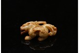 A WHITE AND RUSSET JADE CARVED MYTHICAL BEAST