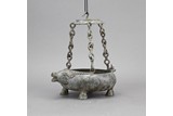 AN ARCHAIC BRONZE 'OX' CANDLE HANGING VESSEL