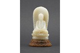 A WHITE JADE CARVED AMITABHA FIGURE WITH STAND