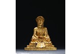 A GILT-BRONZE OF SEATED GURU