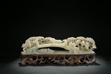 A WHITE JADE CARVING OF FIGURES CROSSING BRIDGE