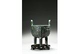 A BRONZE 'TAOTIE' TRIPOD DING VESSEL AND STAND