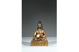 A GILT BRONZE FIGURE OF SEATED GURU