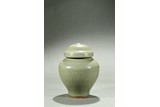 A CELADON CARVED JAR AND COVER 