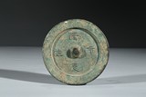 A BRONZE MIRROR WITH FOUR CHARACTERS