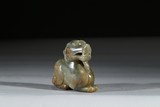 A CARVED CELADON JADE MYTHICAL BEAST