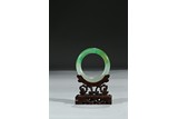 A HARDSTONE CARVED BANGLE WITH STAND