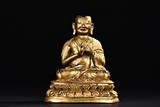 A GILT-BRONZE FIGURE OF GURU