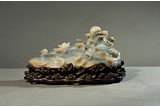 A WHITE AND BLACK JADE CARVING OF CRESTING WAVES & PEARL