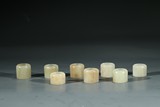 A SET OF EIGHT WHITE JADE ARCHER'S RINGS