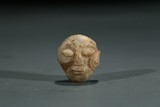 A JADE CARVED 'FACE' BEAD