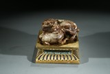 A CELADON JADE BUDDHIST LION AND CUB WITH STAND