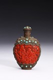 A CARVED CINNABAR LACQUER BRONZE SNUFF BOTTLE