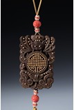 AN AGARWOOD CARVED GOLD INLAID PENDANT