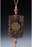 AN AGARWOOD CARVED GOLD INLAID PENDANT