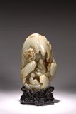 A WHITE JADE CARVED 'LUOHAN' GROTTO WITH STAND
