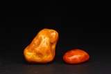 A GROUP OF TWO AMBER CARVINGS