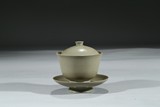 A CELADON GLAZED TEAPOT WITH COVER AND STAND