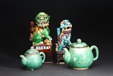 A GROUP OF FOUR GLAZED BUDDHIST LIONS AND TEAPOTS