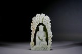 A CHINESE CELADON JADE CARVED BUDDHA IN GROTTO