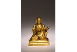 A GILT BRONZE FIGURE OF SEATED LAMA