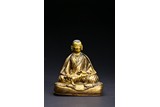 A GILT-BRONZE FIGURE OF SEATED LAMA