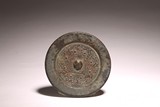 AN ARCHAIC CHINESE BRONZE MIRROR